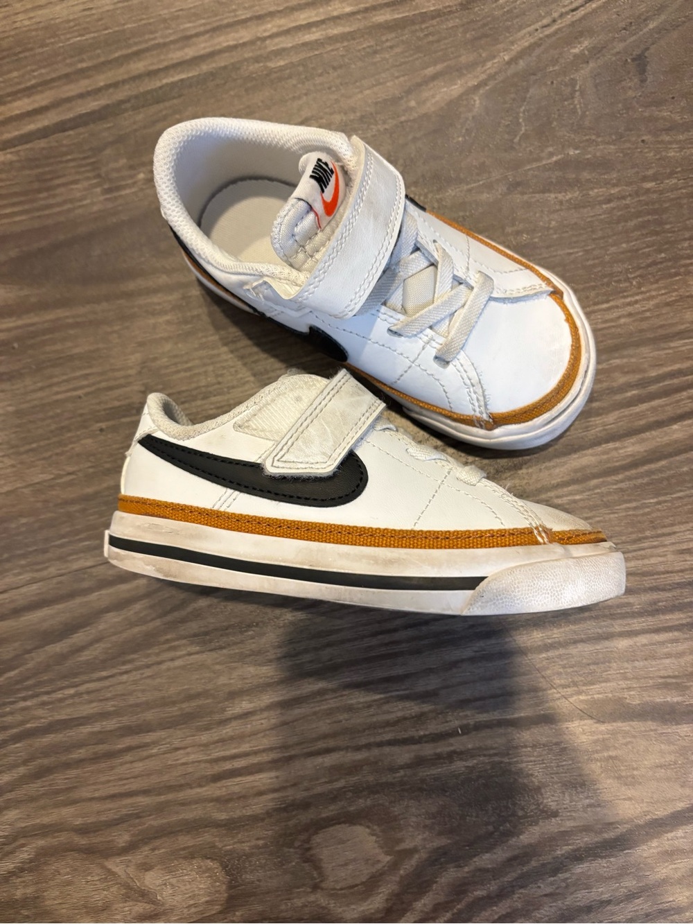 Nike Kids White Sneakers with Black Swoosh and Gold Accent